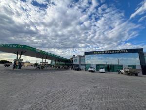 Barra Do Rio GrandeBarra Gold Hotel的加油站外停有两辆车