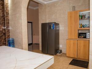 a kitchen with a stainless steel refrigerator in a room at Résidence Akwaba Nukafu in Lomé