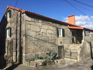 a stone building with a gate in front of it at La casita de piedra in Porto do Son