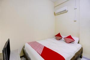 a bedroom with a bed with red pillows on it at Hotel O Ringin Pitu 1 Syariah in Jodoh +17 photos