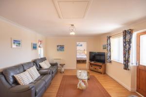 ein Wohnzimmer mit Sofa und Fernseher in der Unterkunft Mermaid - Pet Friendly Self Catering Holiday Cottage Hayle in Hayle