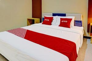 a bedroom with a large bed with two red pillows at OYO Life 91452 Ngajeng Peken Homestay in Batu +16 photos