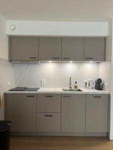 Una cocina con gabinetes blancos y un fregadero. en Waddenhuyske, en Hollum