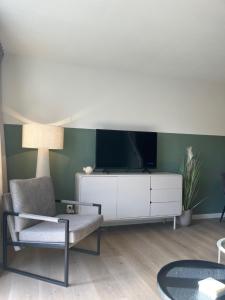 sala de estar con TV y silla en Waddenhuyske, en Hollum