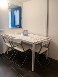 a white table with chairs and a vase on it at Casa Magica Ogliastro in San Marco di Castellabate