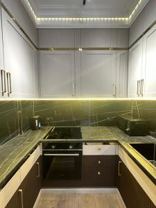 a kitchen with white cabinets and a stove at Luxury apartment Astana Arena in Astana +16 photos