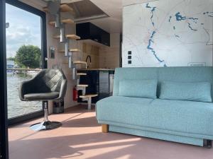 a living room with a blue couch and a chair at Hausbootneuruppin in Neuruppin