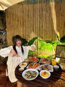a girl sitting at a table with plates of food at Mira Boutique Hotel Quy Nhon in Quy Nhon +83 photos