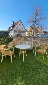 two chairs and a table and a table and two chairs at Privates Zimmer mit Bad in Efringen-Kirchen
