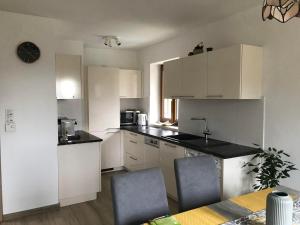 a kitchen with white cabinets and a table and chairs at Ferienhaus Neuhold in Kitzeck im Sausal