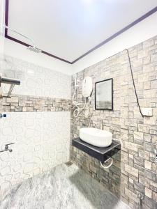 a bathroom with a sink and a stone wall at Villa Serenity in Negombo
