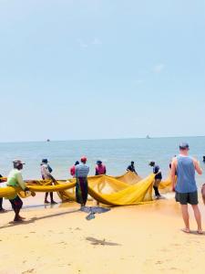 a group of people working on a boat on the beach at Villa Serenity in Negombo