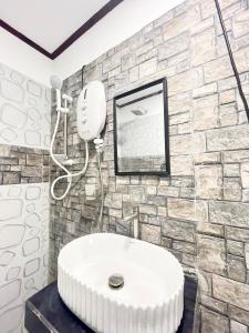 a bathroom with a white sink and a stone wall at Villa Serenity in Negombo