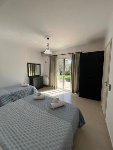 a bedroom with two twin beds and a television at Kouris Apartment Garden View in Chlomatianá