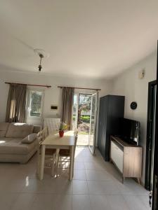 a living room with a table and a couch at Kouris Apartment Garden View in Chlomatianá