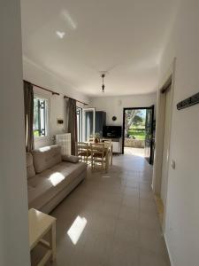 a living room with a couch and a table at Kouris Apartment Garden View in Chlomatianá
