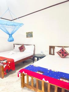 a room with two beds and a blue umbrella at Villa Serenity in Negombo