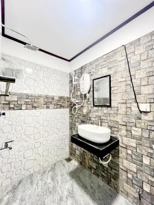 a bathroom with a sink and a stone wall at Villa Serenity in Negombo