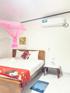 a bedroom with a bed with a pink umbrella at Villa Serenity in Negombo