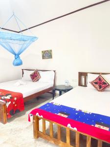 a room with two beds and a table at Villa Serenity in Negombo