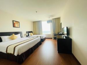 Una habitación de hotel con dos camas y un televisor. en Sai Gon Ban Me Hotel, en Buon Ma Thuot