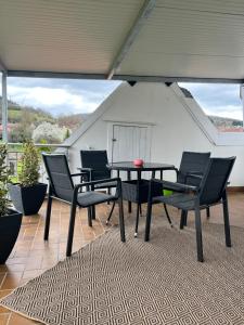 a patio with a table and chairs on a roof at FeWo Rehborn in Rehborn