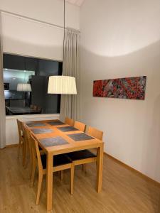 a dining room table with chairs and a painting on the wall at Kylpyla SPA, Saimaa Villa 532 in Imatra +3 photos