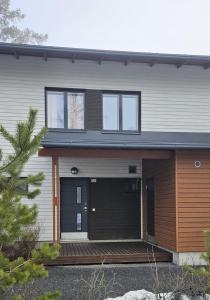 a house with a black front door and windows at Kylpyla SPA, Saimaa Villa 532 in Imatra
