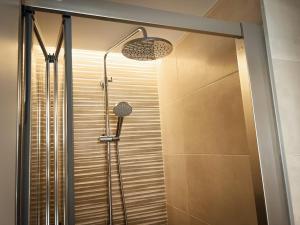 a shower in a bathroom with a glass door at Palm Suites in Alicante