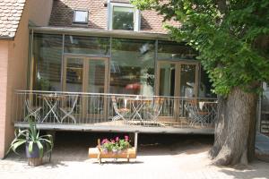 a house with a balcony with tables and chairs at Hotel und Gasthof Ritter St. Georg in Erlangen