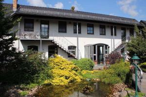 a white house with a pond in front of it at Apartment in Schwielochsee OT Guhlen 36012 in Guhlen