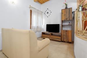 un salon avec une chaise et une télévision dans l'établissement Elia's House, à Porto Istana