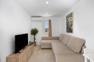 a living room with a couch and a flat screen tv at Villa Pablo in Chiclana de la Frontera