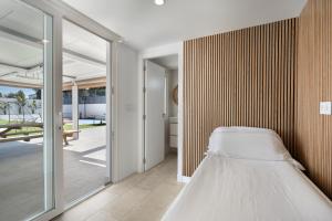 a bed in a room with a sliding glass door at Villa Pablo in Chiclana de la Frontera +25 photos