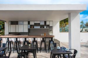 an outdoor bar with black chairs and tables at Casa Bianca Adults Only "by Checkin" in Hersonissos