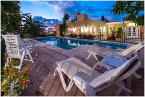 a group of lawn chairs next to a swimming pool at Descanso las Tres Marias Apart Hotel in Villa Carlos Paz