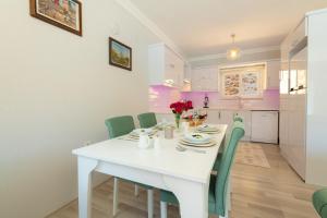 İslâmlarにあるVilla Zia - Countryside and Sea Viewsの白いキッチン(白いテーブル、緑の椅子付)