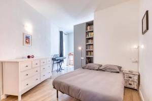 ein Schlafzimmer mit einem Bett und einem Bücherregal in der Unterkunft Maison De Village De 80m2 in Lansargues