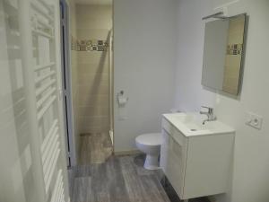 a white bathroom with a toilet and a sink at appartement avec 2 suites parentales in Angoulême