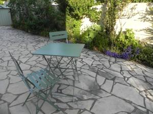 a table and a chair on a stone patio at appartement avec 2 suites parentales in Angoulême
