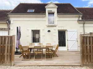 a wooden deck with a table and chairs in front of a house at Gîtes confortables près de Beauval avec wifi et parking - FR-1-491-457 in Meusnes