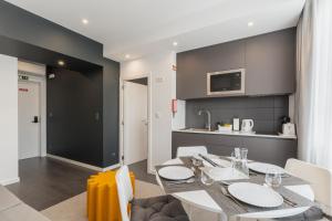 a kitchen and dining room with a table and chairs at Avenida Concept Studios in Aveiro