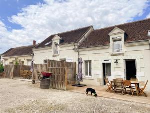 a dog standing on a deck in front of a house at Gîte familial avec terrasse privative près de Beauval - FR-1-491-461 in Meusnes