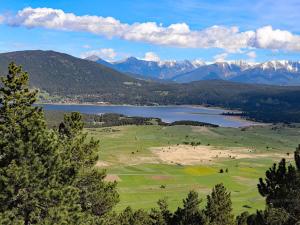 a view of a golf course with a lake and mountains at Appartement T3 avec garage, proche des pistes, 6 couchages - FR-1-295-205 in Les Angles