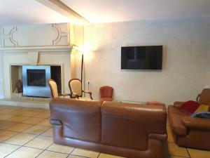 a living room with a couch and a flat screen tv at Le Moulin de Ronsard : Demeure spacieuse, jardin et vue sur le Loir - 8 personnes - FR-1-491-459 in Couture-sur-Loir