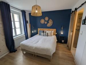 une chambre avec un lit avec un mur bleu dans l'établissement Chambre cosy à Briare, centre-ville, idéale pour cyclistes - FR-1-590-571, à Briare