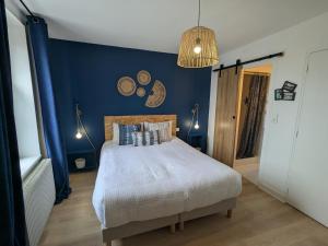 une chambre avec un lit avec un mur bleu dans l'établissement Chambre cosy à Briare, centre-ville, idéale pour cyclistes - FR-1-590-571, à Briare 9 autres photos