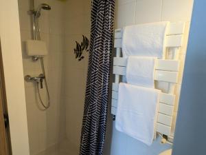 une salle de bain avec douche, serviettes et rideau de douche dans l'établissement Chambre cosy à Briare, centre-ville, idéale pour cyclistes - FR-1-590-571, à Briare