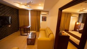 a hotel room with a couch and a bed at Dev Residency in Attingal