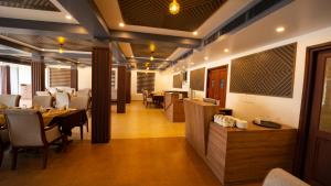 a restaurant with a dining room with tables and chairs at Dev Residency in Attingal